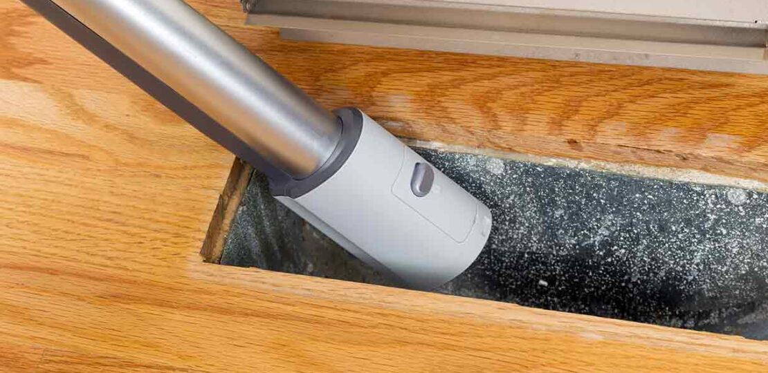 cleaning-dusty-floor-vent-with-vaccum-hose