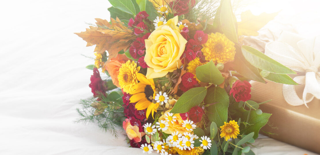 colorful-beautiful-spring-summer-bouquet-flowers-bed-with-golden-gift-box-holiday-surprise-concept